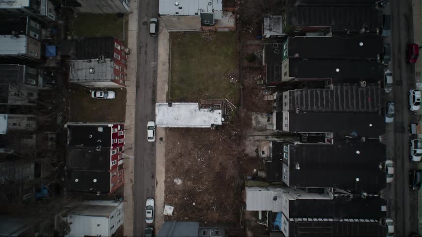 Cars are parked on city streets lined with buildings