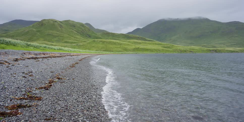 Waves roll onto a gravel shore