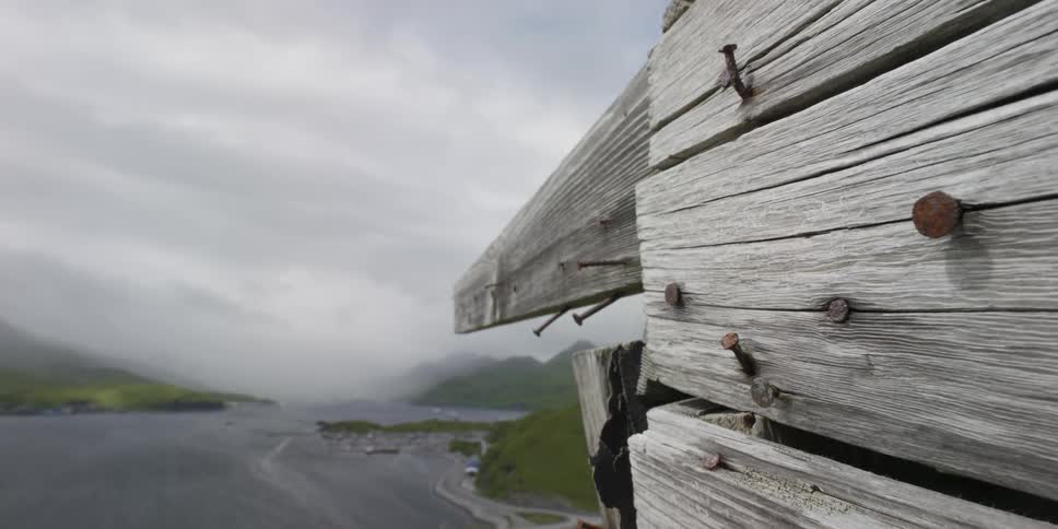 Clouds roll over an ocean bay and wood structure