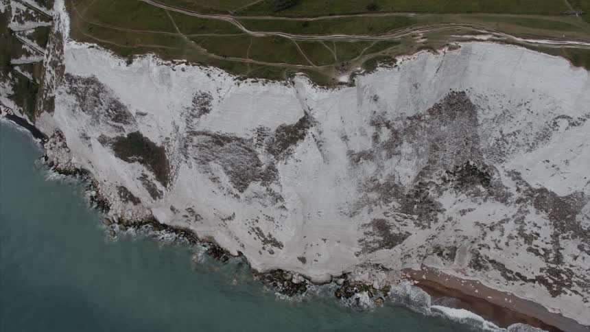 Ocean waves splash against the cliffs