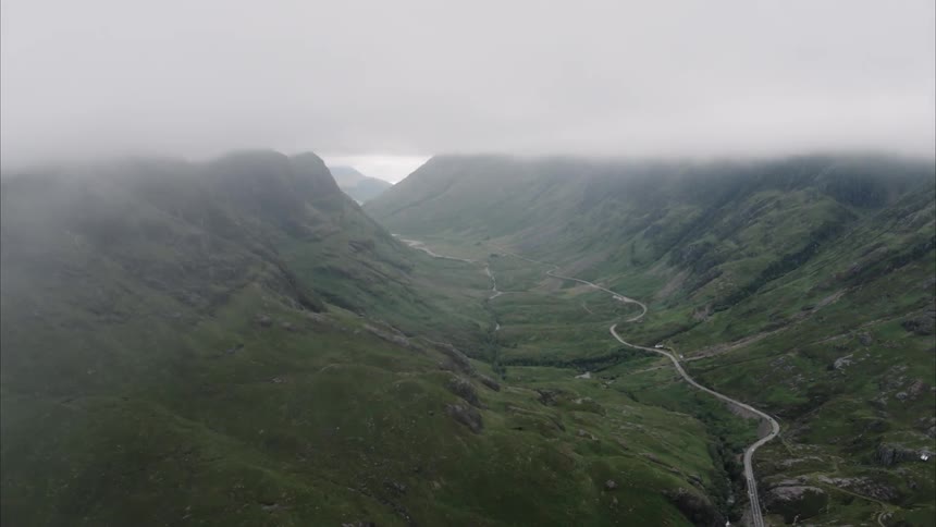 Grassy hilly land covered in fog