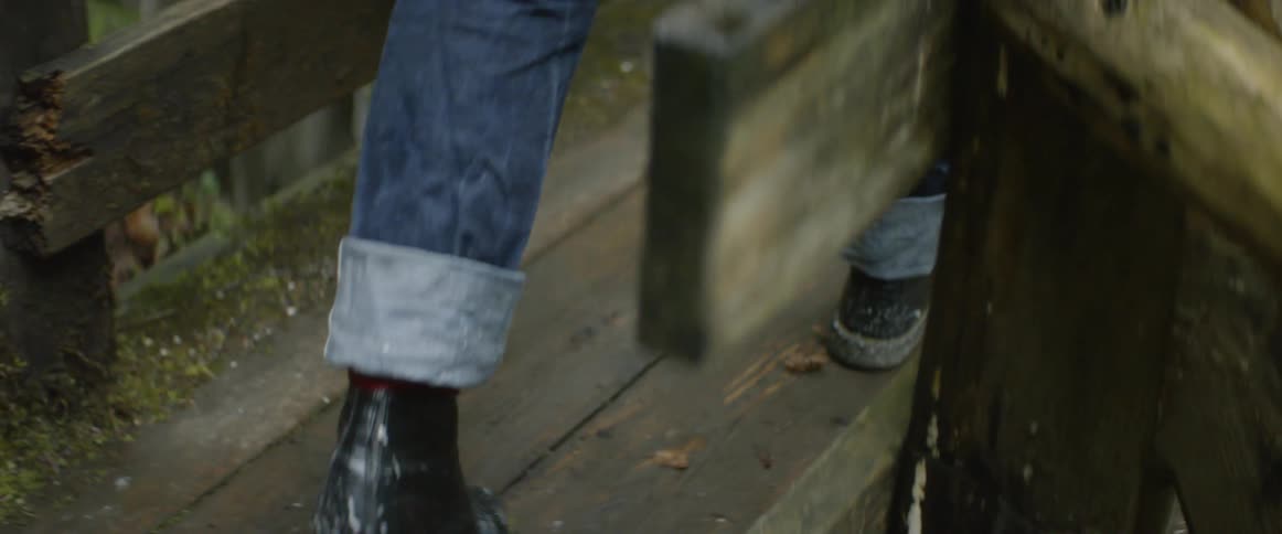 Someone walking across a wooden bridge