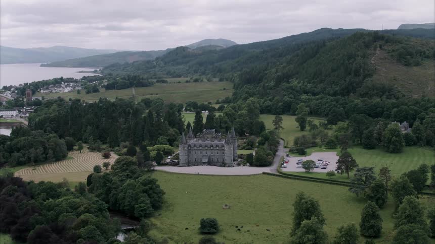 Castle in hilly grassy land near a body of water