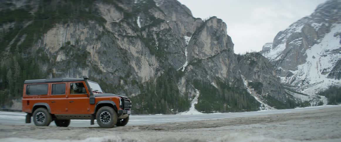 A jeep is driving over some rocky land