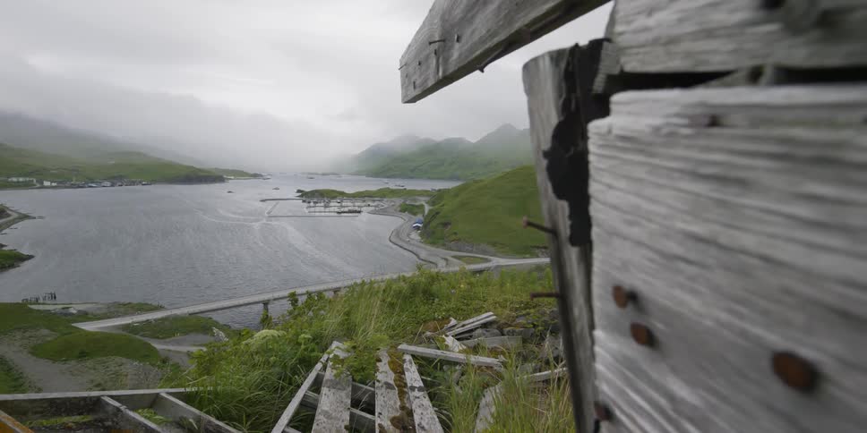 An old wood structure sits next to a bay