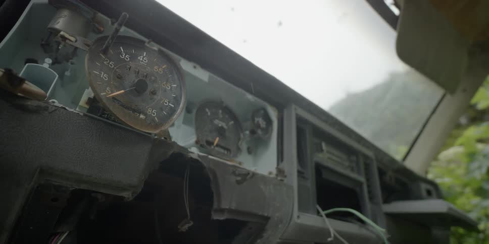 Rain is falling into the interior of an abandoned vehicle during the day