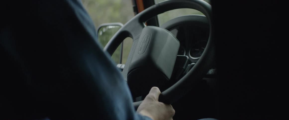 A person turning a steering wheel