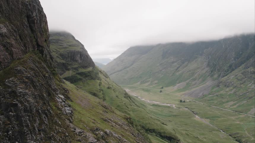 Clouds hover over a mountain valley