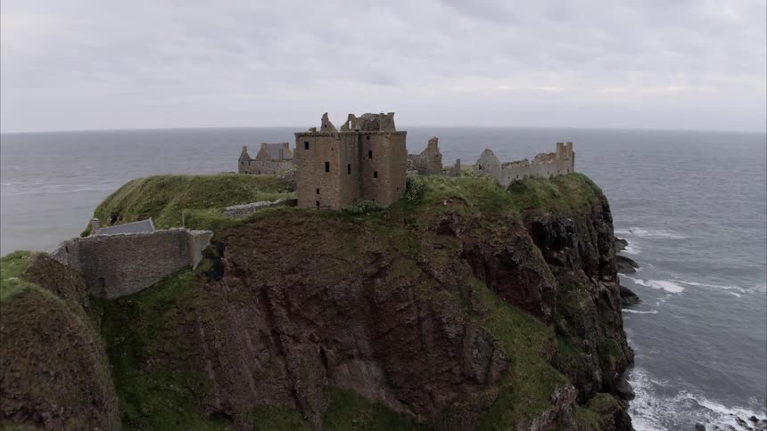 A crumbling stone wall and fort on top of an ocean side hill
