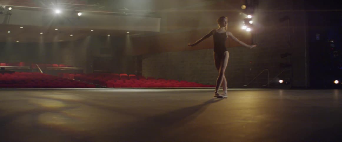 A ballerina practices her moves on a stage