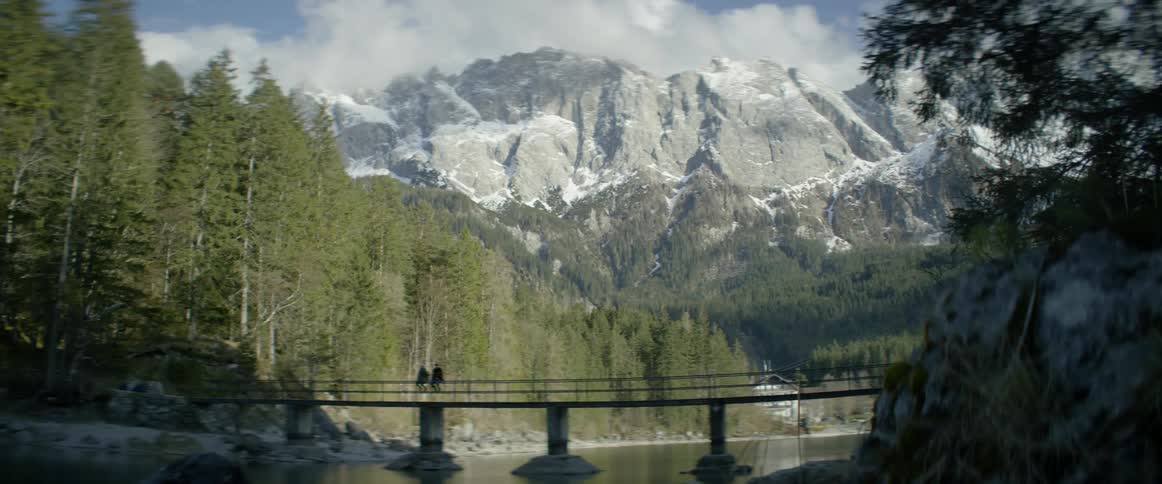 People cross a river bridge