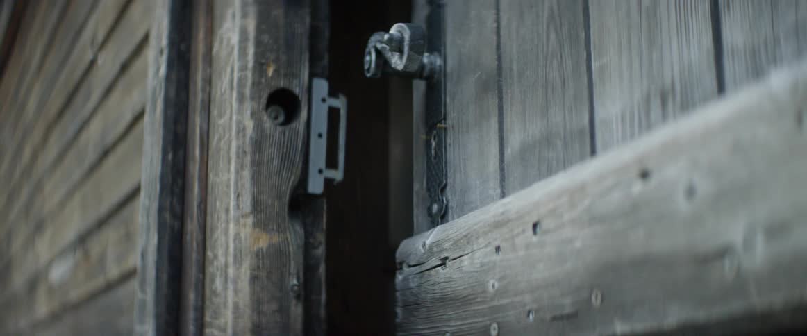 An old wood door is cracked open