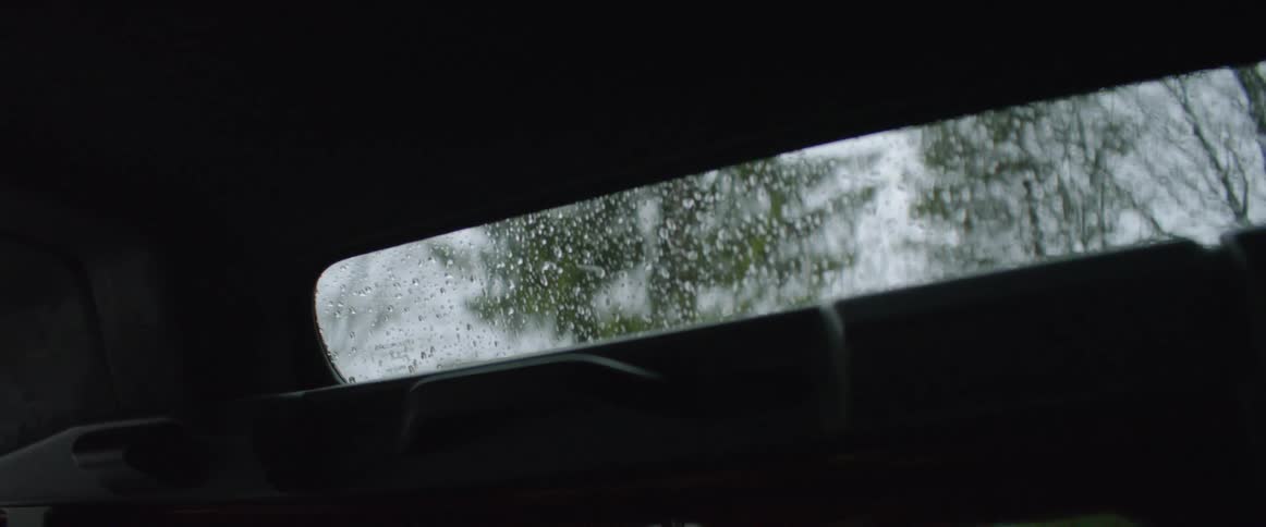 Raindrops falling onto the outside of car window