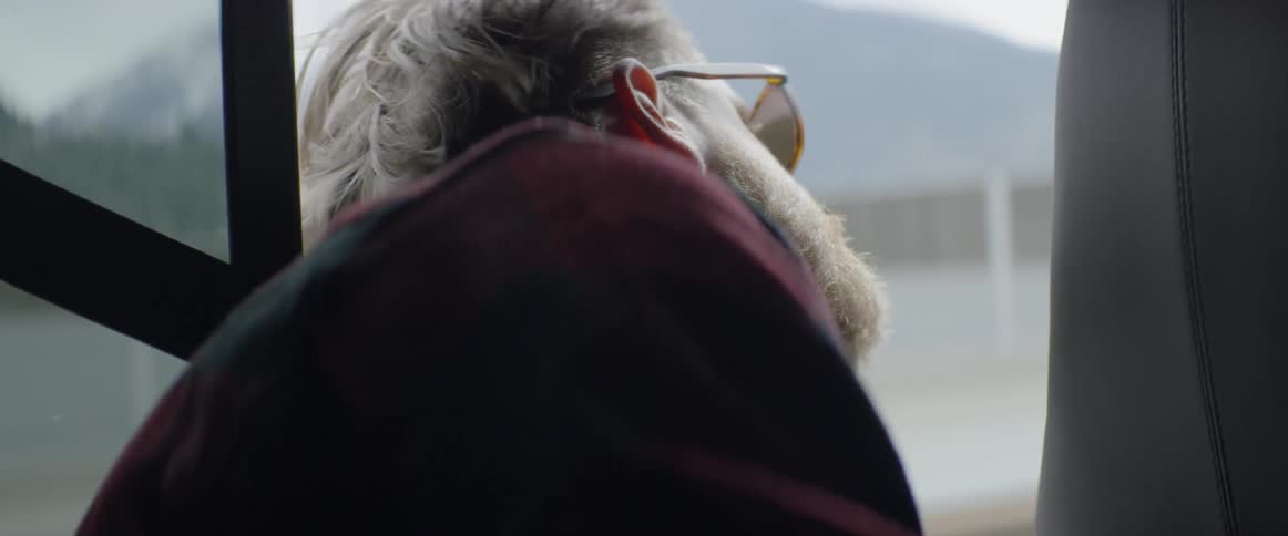 Man hanging his head out window while traveling in car