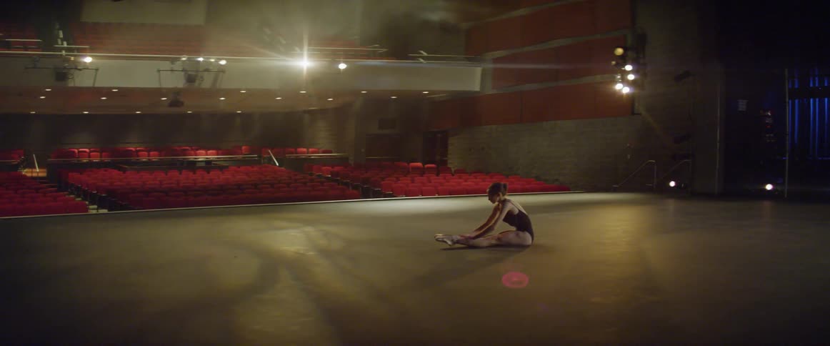 A ballerina stretches on a stage