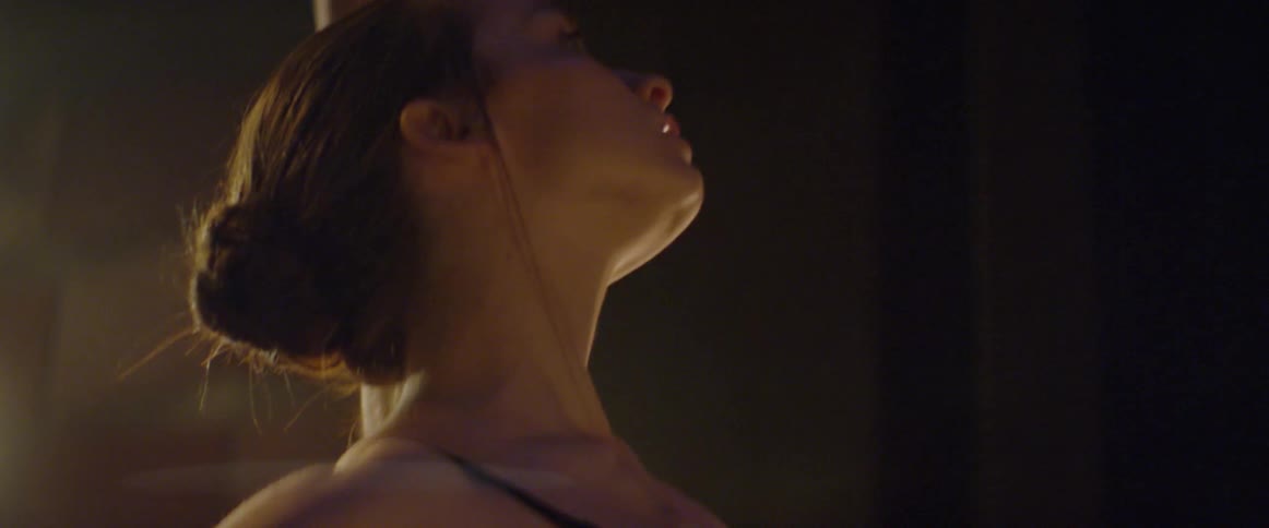 Young ballerina dancing indoor in front of lights