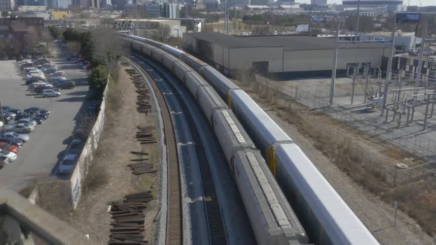 View of trash littered bridge as two trains pass under it