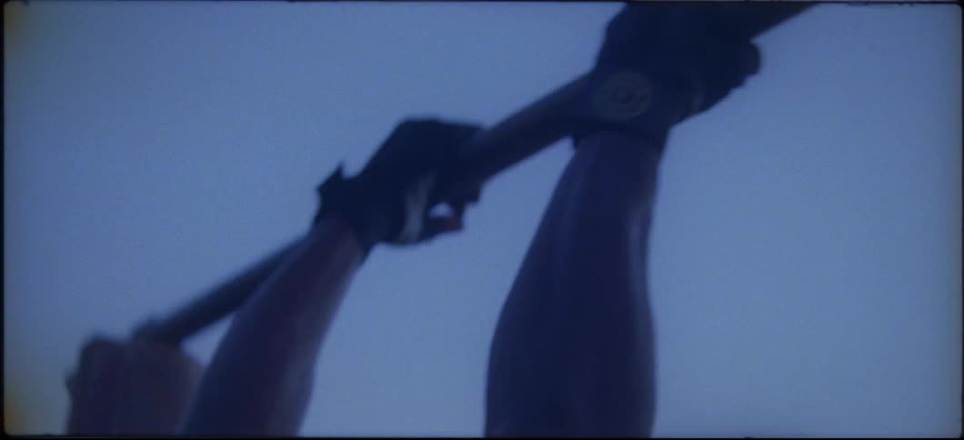 A man exercises on pull up bars outside