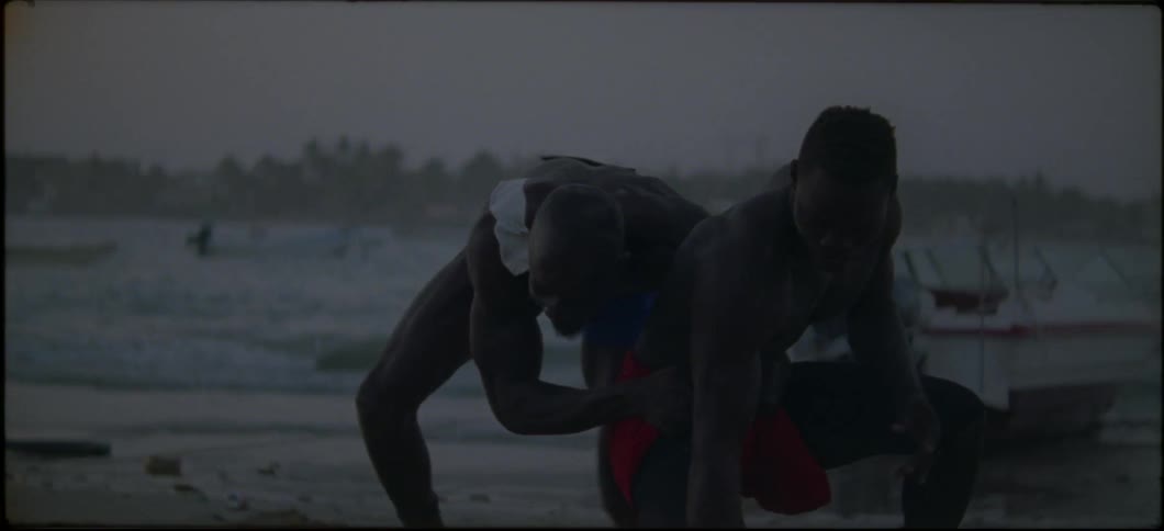 Men wrestling on a beach