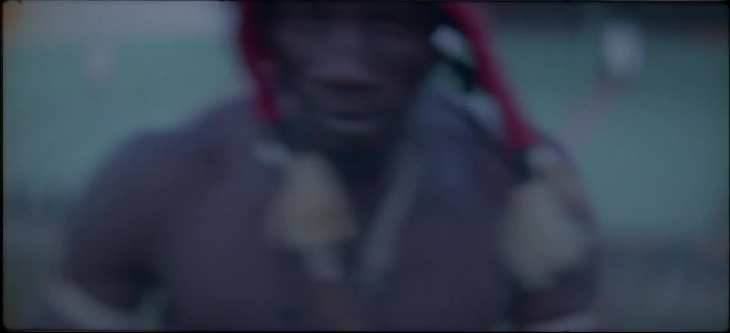 Shirtless man wearing red hat jumps and punches