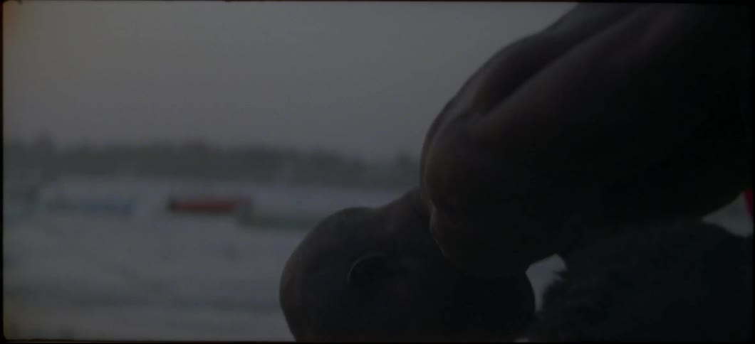 Two men are wrestling on a beach