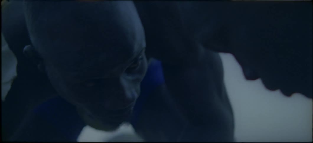 Two men are bent over next to each other staring at each other