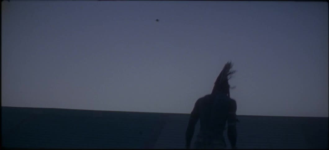A man bounces outside while wearing a headdress at dusk