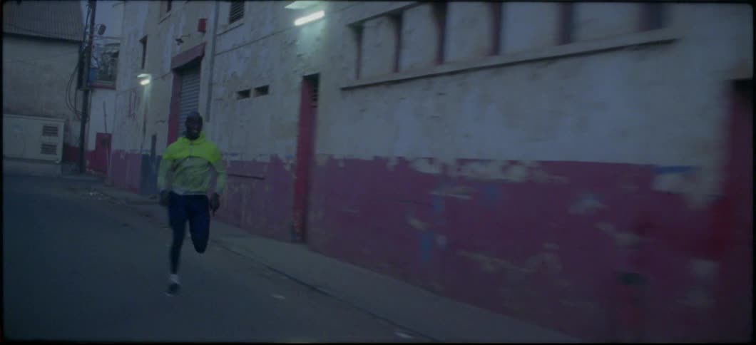 A man races down the alley at dawn