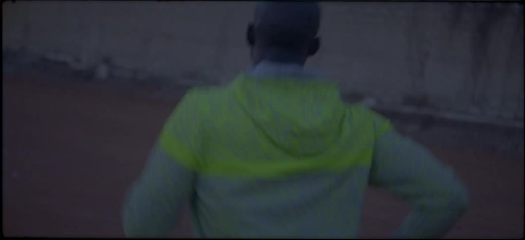 A man is running around an orange colored track
