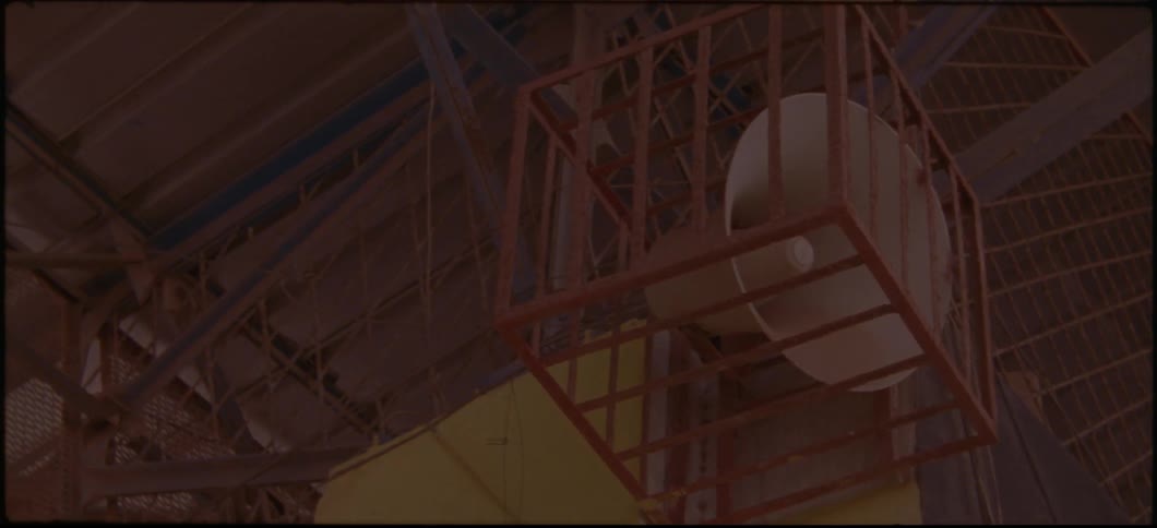 A loudspeaker sits inside a cage in an arena