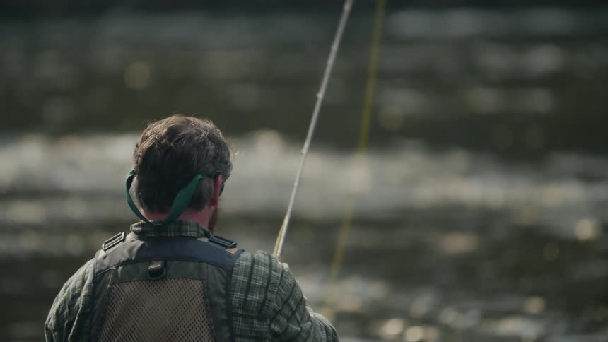 Man fishes in a flowing river