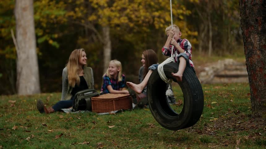 A child swings on a tire swing in the park