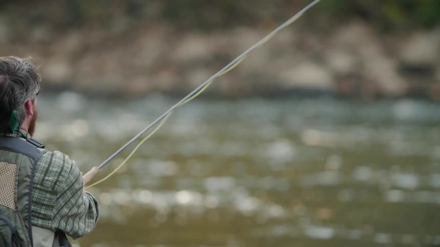 A man casts his fishing line into the water