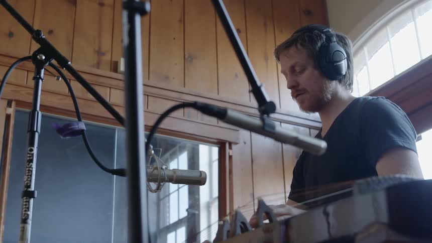 A man plays an instrument in a recording studio