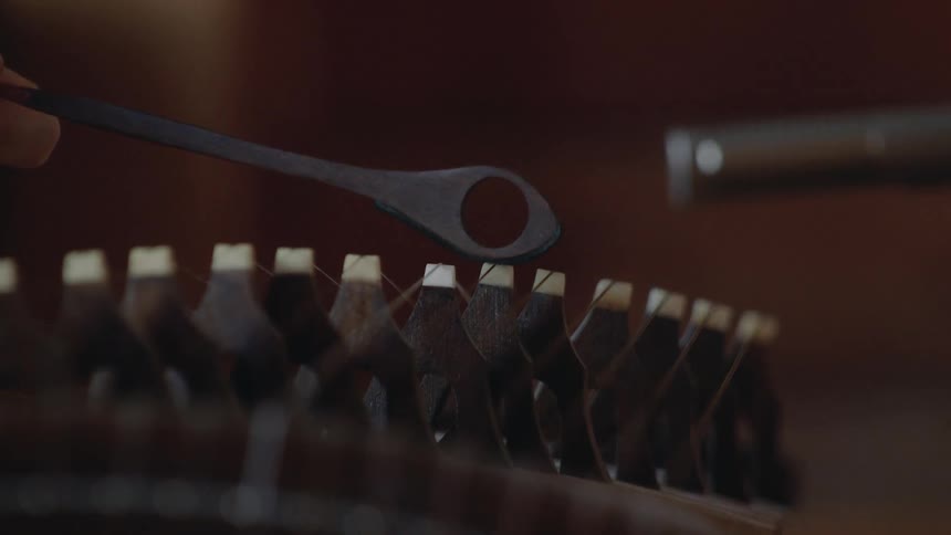 Person taps keys on an instrument with a small object