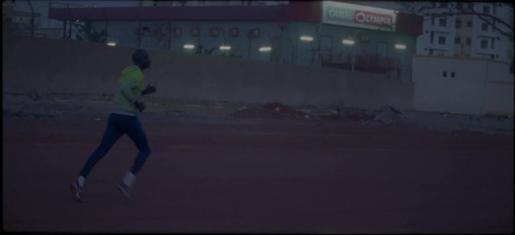A man races down the field at sunset