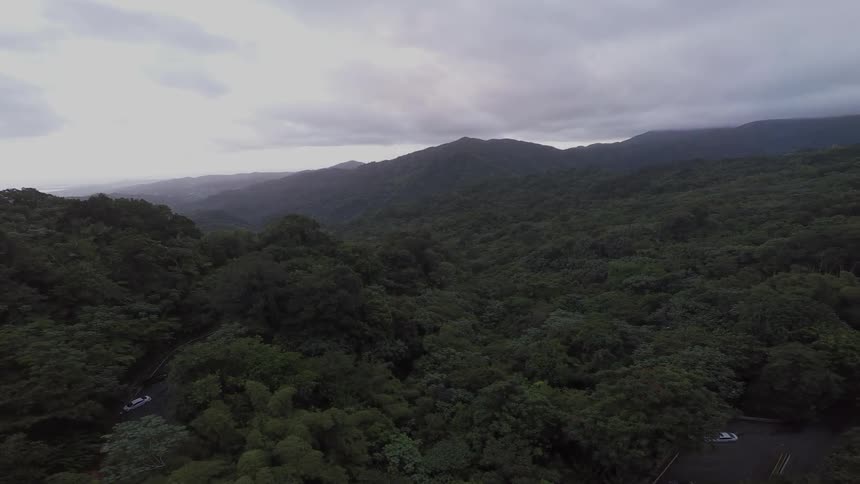 An aerial view of the mountains under a cloudy sky