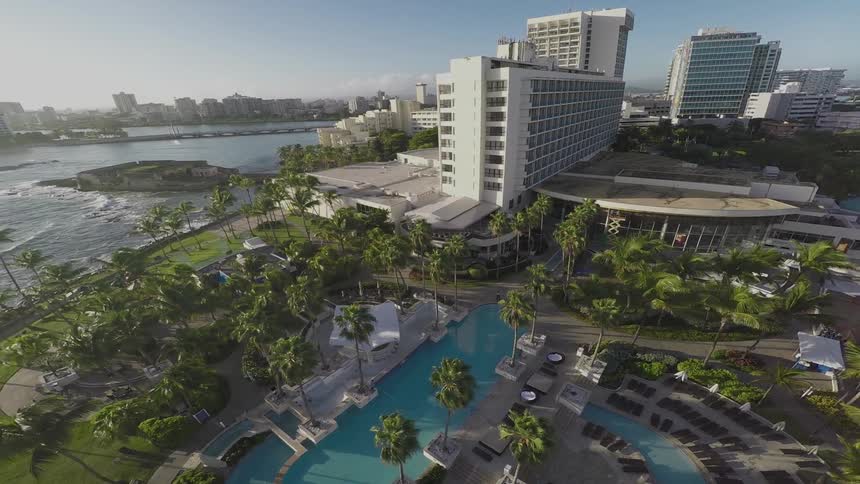 Aerial view of a resort with palm trees by the water