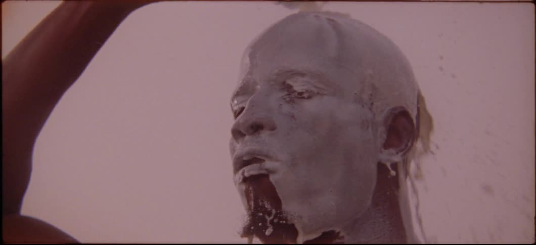 A man is pouring white liquid out of a bottle and over his head