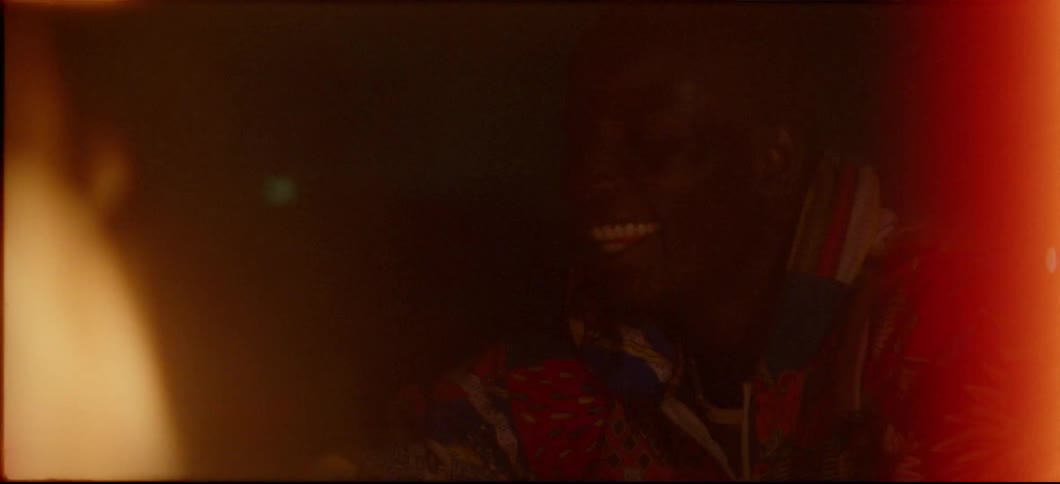 People are sitting around a fire and laughing