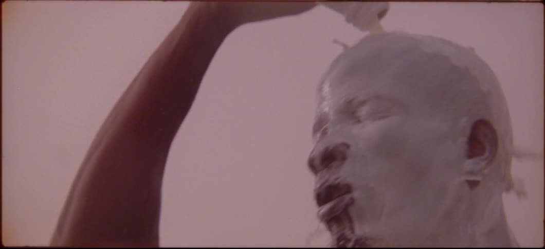 A man is pouring a bottle of white liquid over his head