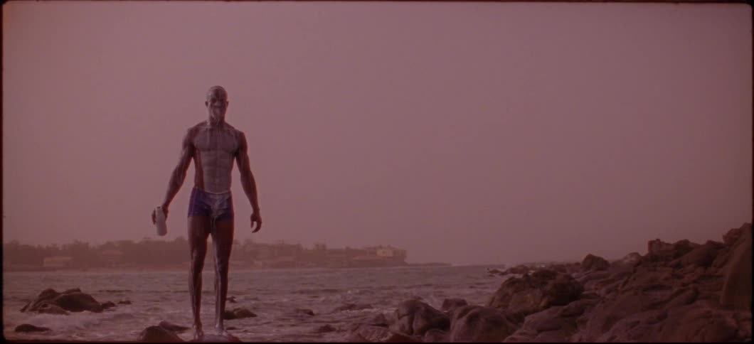 A man is covered in a white liquid which he poured over his head and body