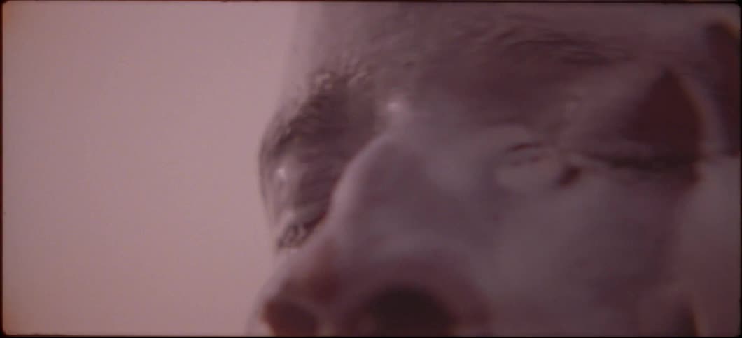 A man is having a white liquid poured on his face