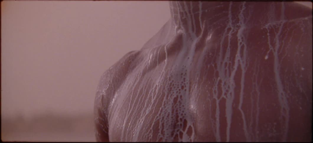 A man has white liquid streaking down his shirtless body