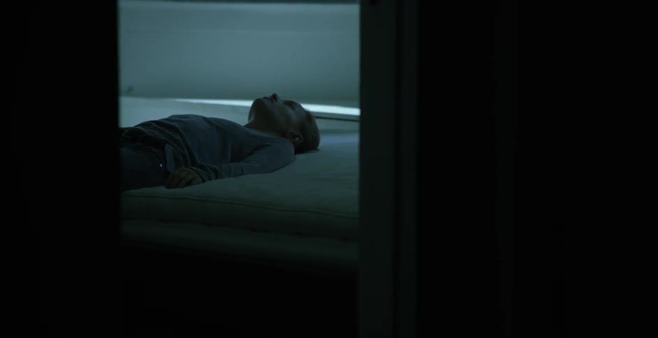Person lying on a floor in a room very still