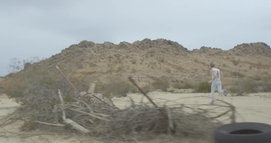 A man in white runs through the desert