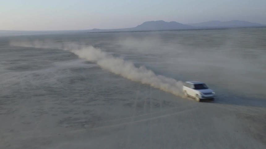 A car speeds through a flat desert