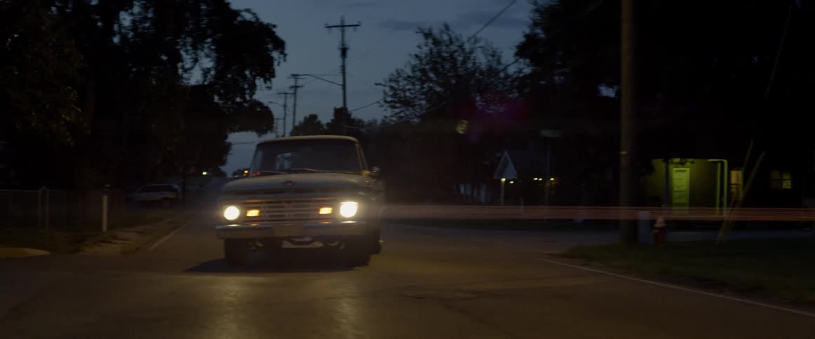 An old pickup truck turns onto a street