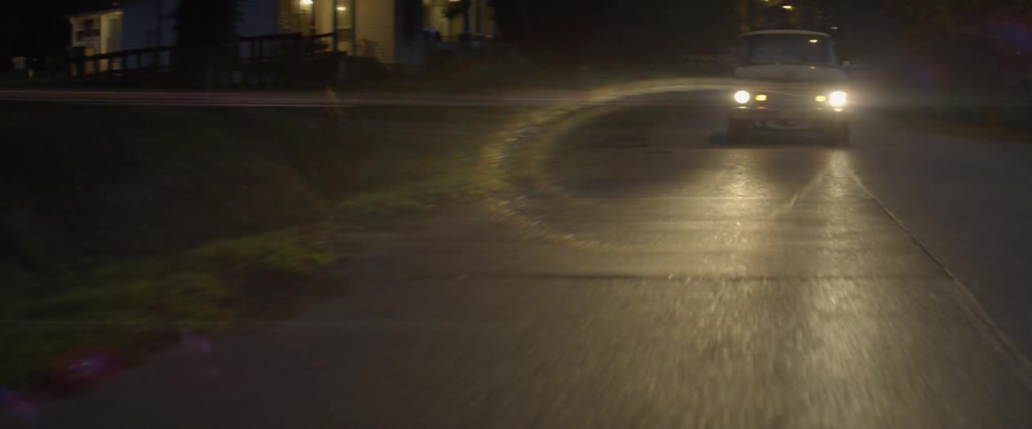 Vehicle drives in a residential area at night