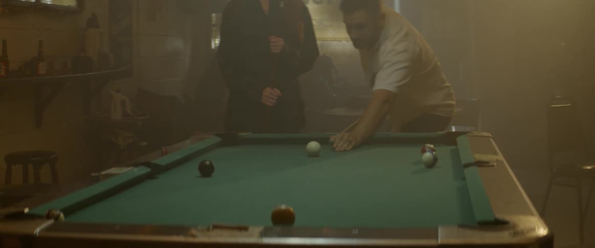 Man and woman play pool in a bar
